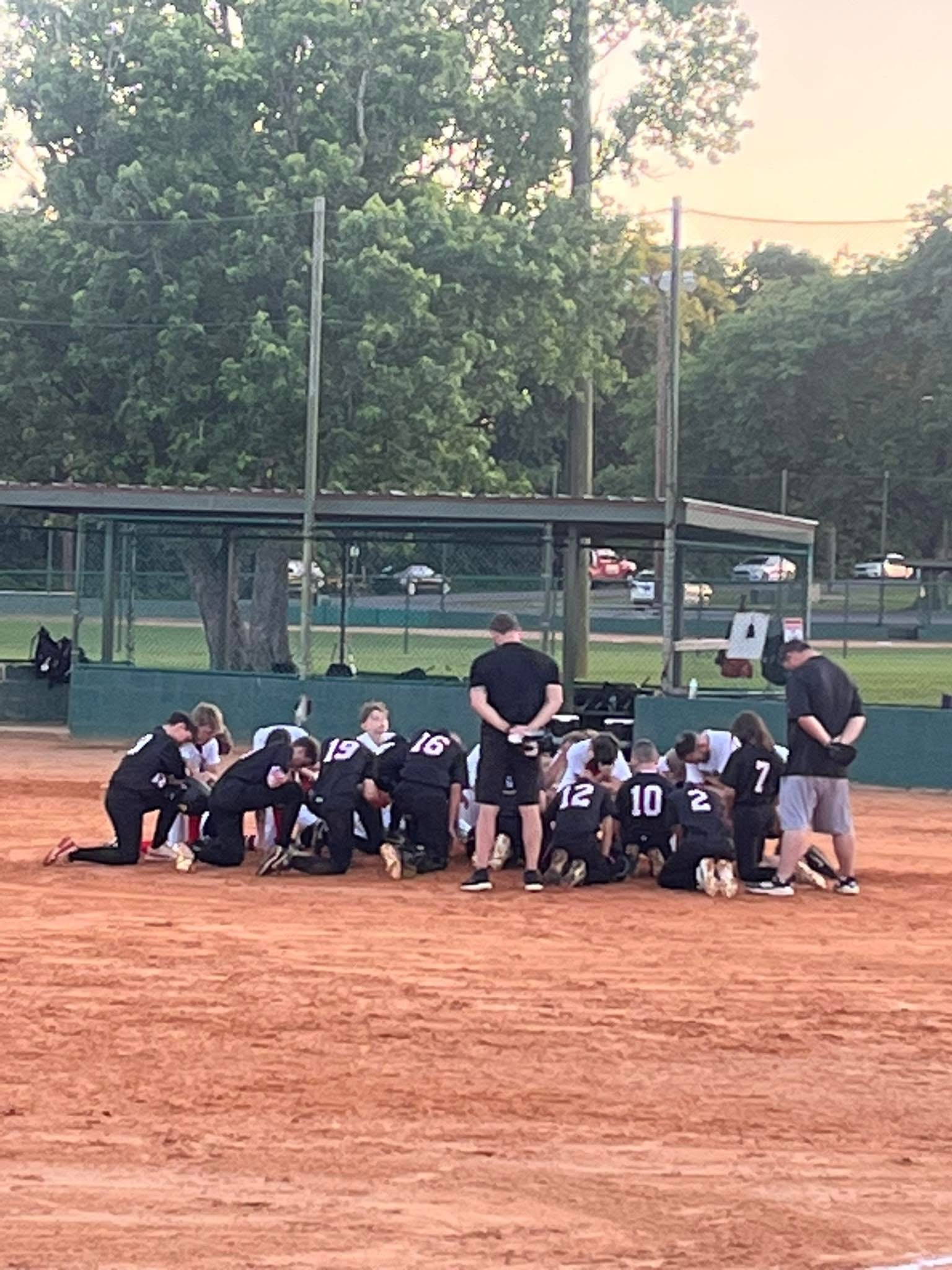 Dirt Dogs team huddle with coach on the field